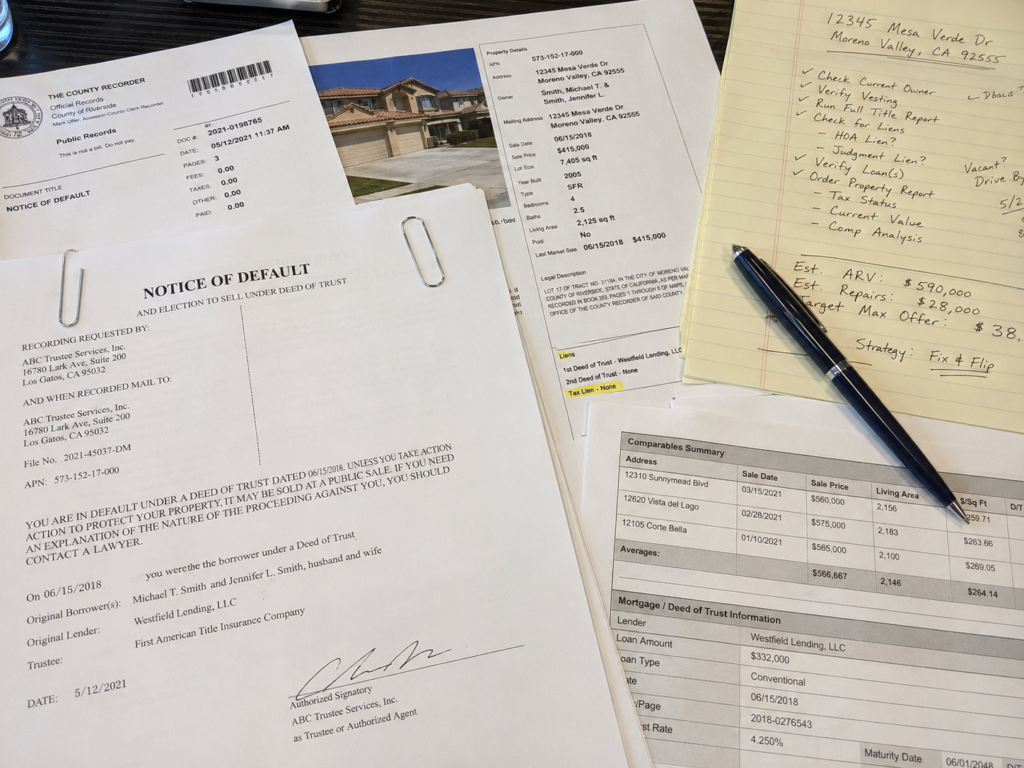 a close-up of foreclosure public records, notice of default documents, and property research notes
