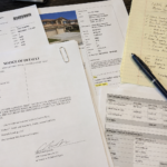 a close-up of foreclosure public records, notice of default documents, and property research notes