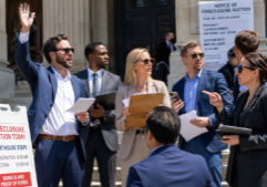 A group of real estate investors on the court house steps bidding on foreclosure properties on a bright sunny day.
